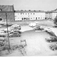 SLM R13-88-10 - Parkering med hus i bakgrunden, vid Östra kyrkogatan i Nyköping