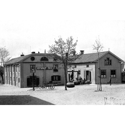 SLM M027505 - Bild av torget med restaurant Fenix, Spritbolaget med mera. Foto 1890