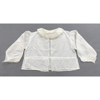 SLM 52463 - Babyskjorta av tunn linnebatist med knytsnodd i midjan, prydd med spetsar