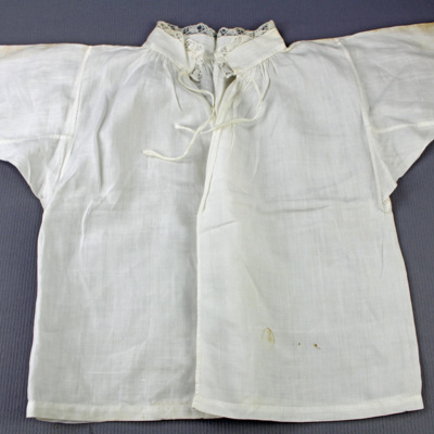 SLM 28334 - Babyskjorta av vitt linne med knypplad spets, från Ökna i Floda socken
