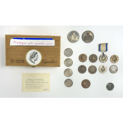 SLM 39056 1-18 - Cigarrlåda innehållande medaljer mm, från Ökna i Floda socken, 1800-tal