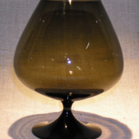 SLM 28157 - Skål på fot, närmast klotformad kuppa i brunt glas, påminnande om tulpanglas, design möjligen Nils Landberg