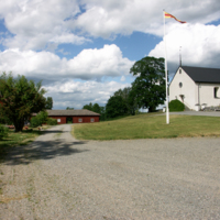 SLM D10-386 - Husby-Oppunda kyrka, kyrkoanläggningen från sydväst med kyrkstall till vänster.