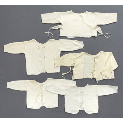 SLM 52951, 52956, 52957, 54781, 54782 - Fem babytröjor av vit bomullstrikå dekorerade med uddkant