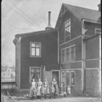SLM P07-047 - Ett tiotal personer framför Jurells gård på Malmgatan i Oxelösund