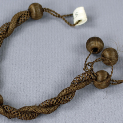 SLM 8325 1 - Armband, hårarbete, två sammantvinnade flätor, hårklädda träkulor