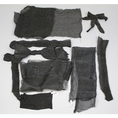 SLM 23063 - Textiler använda vid sorg, tygstycke av svart crepelin och ärmbindel av silkestrikå