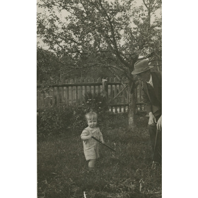 SLM P2022-1264 - En man och ett barn i en trädgård