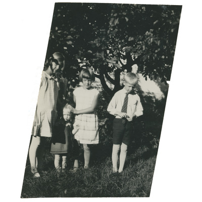 SLM P2022-0042 - Porträtt på fyra barn i en trädgård, 1920-talet