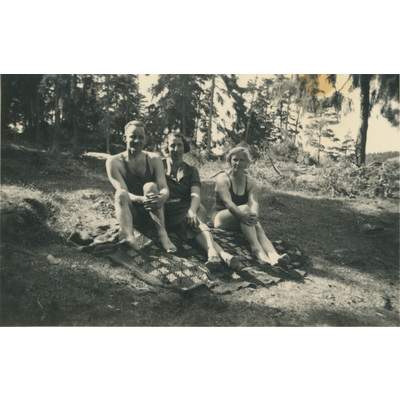 SLM P2022-0943 - En man, Karin och Gertrud Höglund på en filt