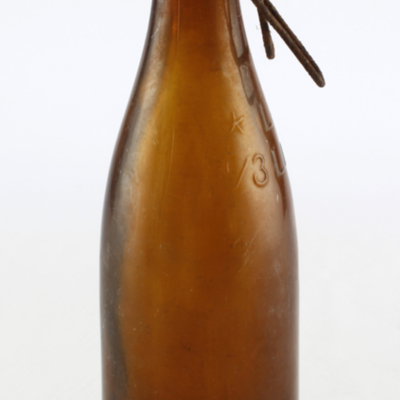 SLM 25615 - Ölflaska av brunt glas, så kallad knoppflaska, med metallbygel