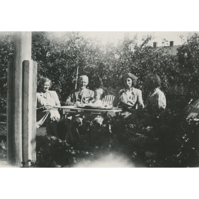 SLM P2022-0935 - Medlemmar ur familjen Höglund fikar i en trädgård