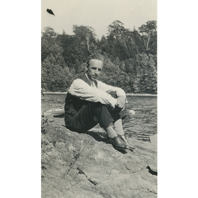 SLM P2022-1153 - Einar Höglund sitter på en klippa vid vattnet, 1926