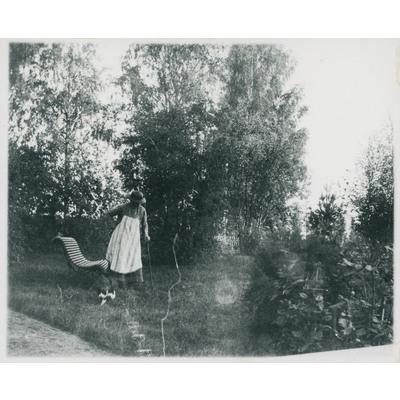 SLM P09-1604 - Fotografi av kvinna och katt i trädgård