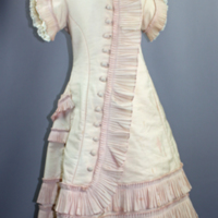 SLM 11885 - Flickklänning av rosa yllemuslin med plisserade volanger, ca 1880