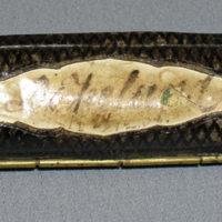 SLM 11936 - Cigarretui, spolformat av skinnklädd metall, namninskription D. Ekelund