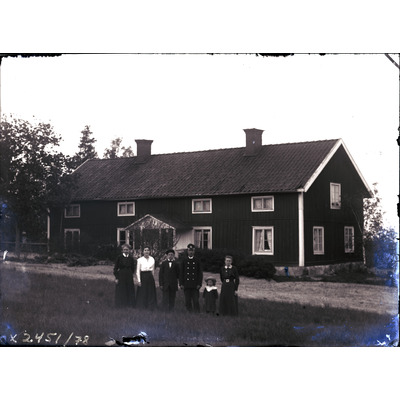 SLM X2451-78 - Familjeporträtt på en äng framför ett hus