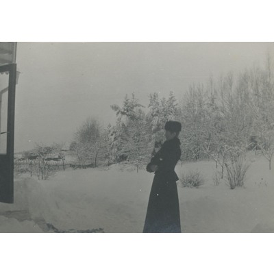SLM P09-1472 - Kvinna med katt i famnen i vinterlandskap