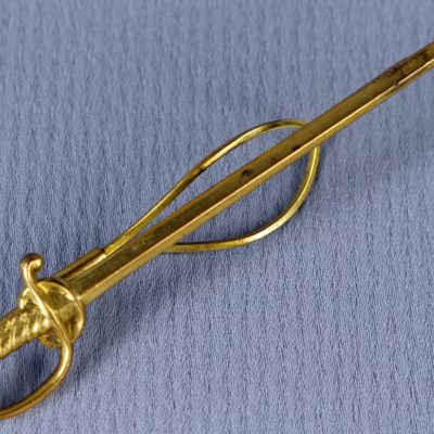 SLM 31100 12 - Slipsnål i form av sabel, gulmetall