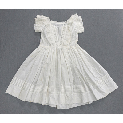 SLM 52532 - Kolt/klänning av vit bomull, prydd med volanger och spetsar