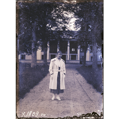 SLM X1809-78 - Porträtt på en kvinna framför en okänd herrgård