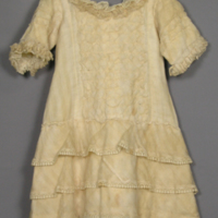 SLM 11916 - Barnklänning av bomull prydd med gasväv och spetskantade volanger, 1880-tal