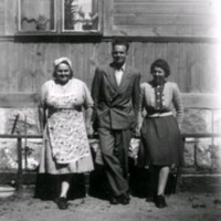 SLM M029906 - En man och två kvinnor framför en husvägg