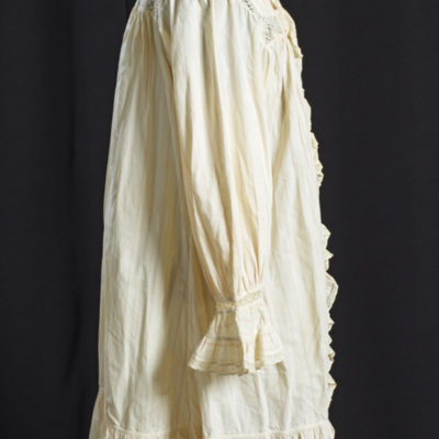 SLM 11714 - Peignoir, kamkofta eller morgonklänning av vit bomull med invävda röda ränder, volanger och spetsar, 1800-tal