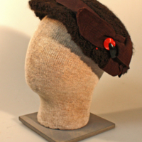 SLM 10291 - Hatt av brunt fårskinnimiterande tyg med band och rosett, 1940-tal