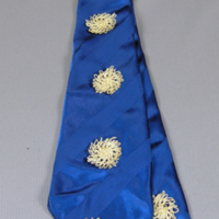 SLM 22039 - Slips av blått randvävt siden prydd med virkade blommor i vitt, från klänning