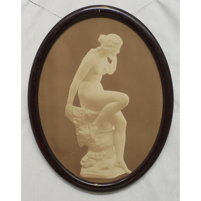 SLM 9626 - Inramat foto föreställande staty med sittande naken kvinna