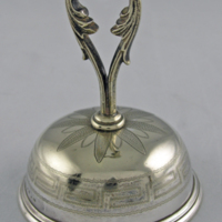 SLM 24517 - Halvklotformad silverklocka, dekorerad med meanderbård, serveringsklocka