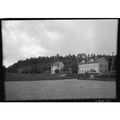 SLM X209-84 - Trähus vid en åker i Malmköping