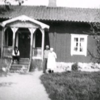 SLM M029096 - Två män och en kvinna framför ett hus.