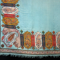 SLM 5959 - Schal av ljusblå ylle, bårder i orientaliskt inspirerat mönster.