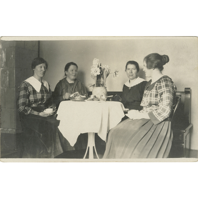 SLM P2022-0606 - Fyra kvinnor fikar vid dukat bord