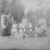 SLM X10-299 - Grupporträtt, personer samlades runt ett bord utomhus, 1920-tal