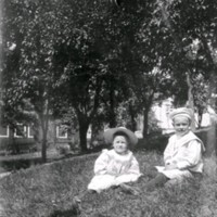 SLM M034035 - Två barn sitter på gräsmattan.