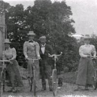 SLM M034059 - Tre kvinnor och en man med cyklar.