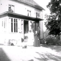 SLM Ö248 - Två kvinnor och två hundar framför ett hus