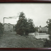 SLM 29037 - Inramat fotografi, Periodens bomullsspinneri vid ån, med kraftstationen till höger, troligen 1940-tal