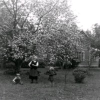 SLM M029563 - En sköterska och två barn i en trädgård.