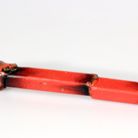 SLM 25947 36 - Lackstång av röd lack, spår av eld