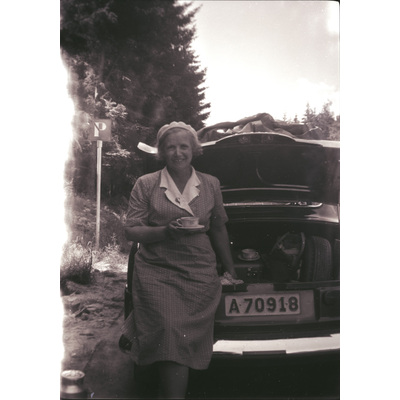 SLM X2022-0012 - Gertrud Höglund dricker kaffe vid bilen