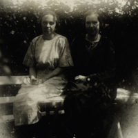 SLM P08-2212 - Två kvinnor sittande på trädgårdsbord