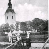 SLM M028755 - Kvinnor i folkdräkt framför Vingåkers kyrka