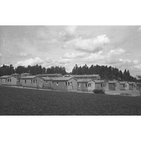 NKBFA DS1285 -  
Estlandsbyn vid Harg.
 De närmaste små husen byggde åt Balter som tagit sig till Sverige undan förhållandena i Baltikum på 1940-talet. De fick arbete inom textilindustrin. Området kallades Balthusen