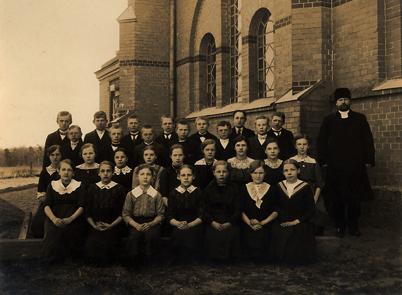 1914 års konfirmander utanför kyrkan. Kyrkoherd...