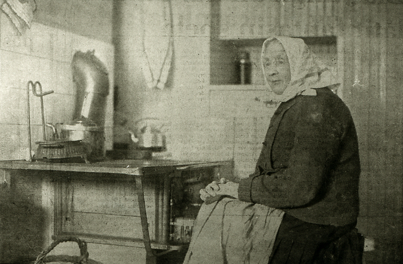 Fru Elna Rosenlöf (1842-1925) värmer sig vid sp...