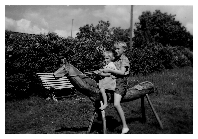 000684 - Två barn på en hemmagjord trähäst.